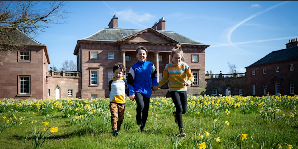 A small group of children running in the garden of Paxton House.